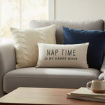 Beige pillow with text 'Nap time is my happy hour' on a white background