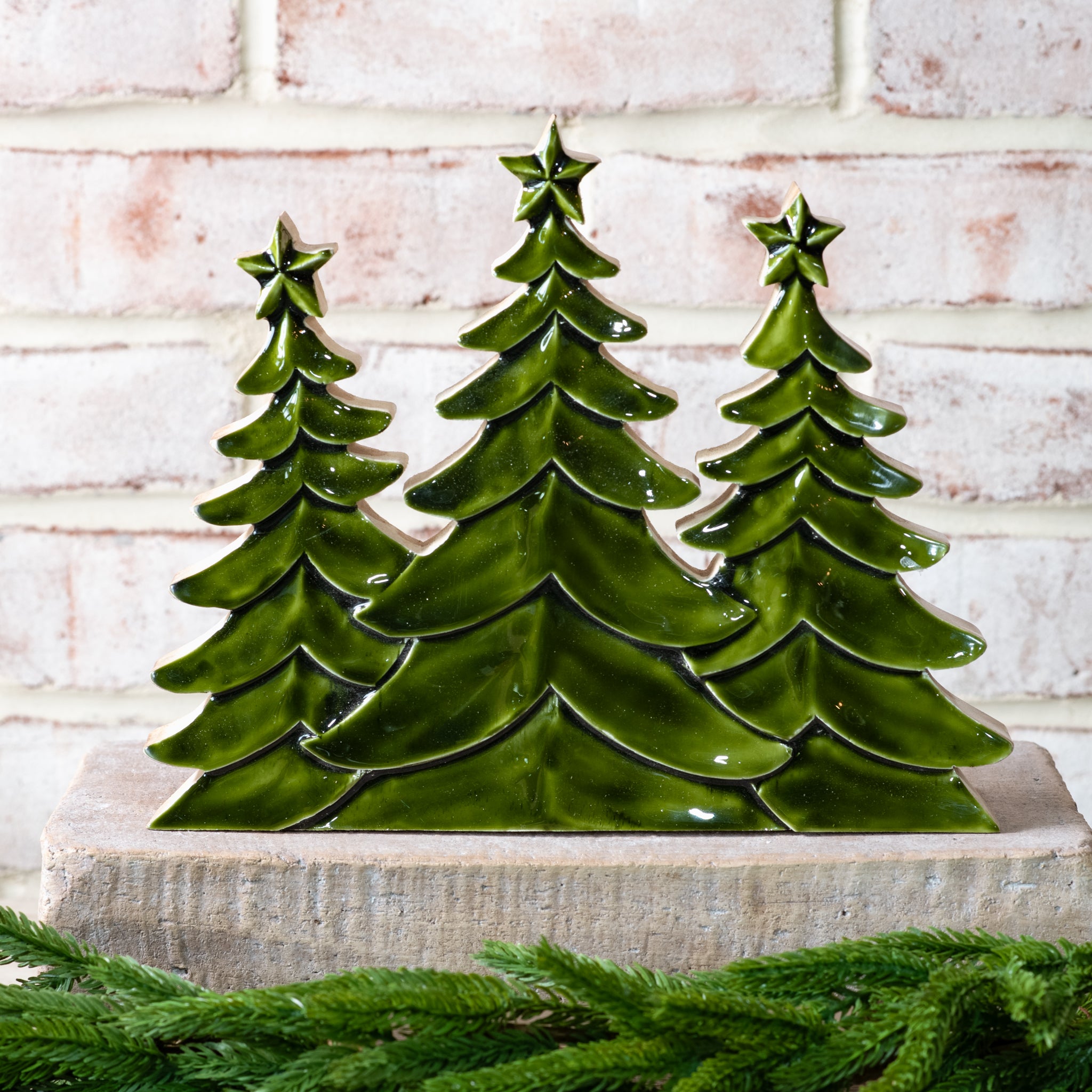 Tall trio of glossy green wood trees with star tops