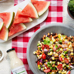 Bean and corn salad with watermelon and chips alongside Cilantro Lime Ranch Dressing