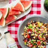 Bean and corn salad with watermelon and chips alongside Cilantro Lime Ranch Dressing