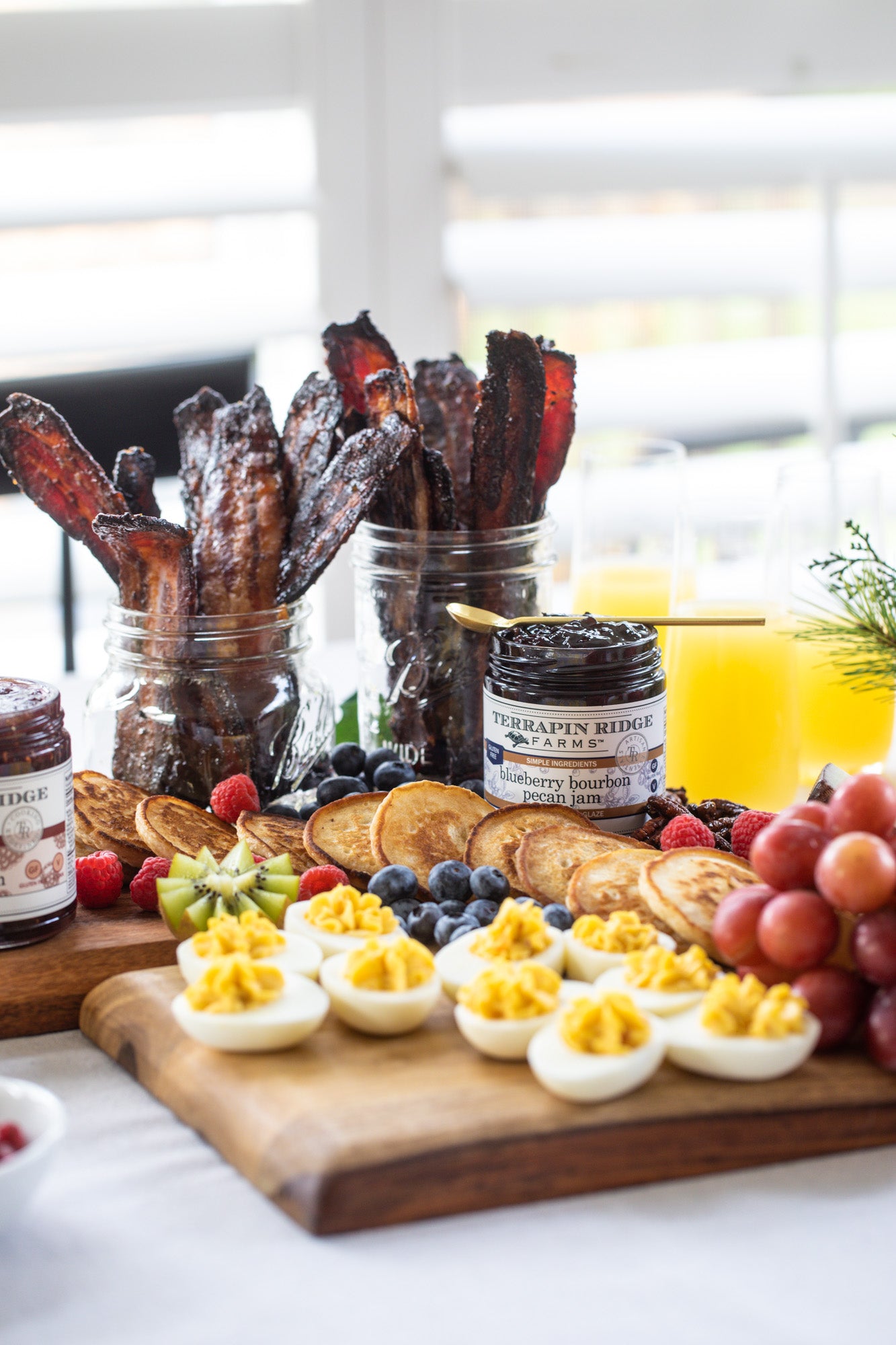 Breakfast board with pancakes, bacon, fruit and Blueberry Bourbon Pecan Jam