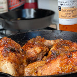 Chicken glazed with Hot Pepper Peach Bourbon Sauce in a cast iron skillet