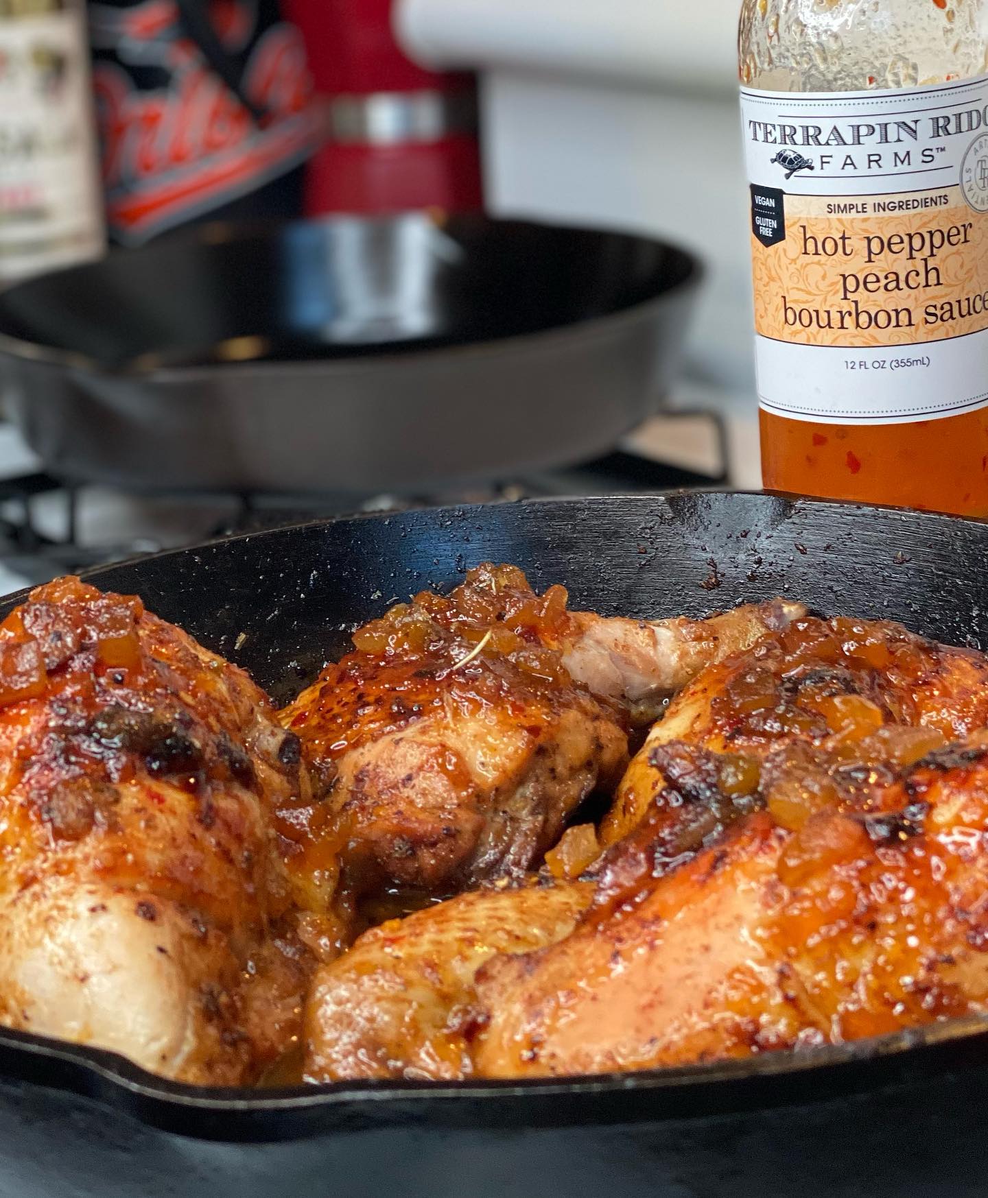 Chicken glazed with Hot Pepper Peach Bourbon Sauce in a cast iron skillet