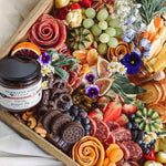 Bacon Pepper Dip on a wooden platter with cheeses, meats, fruit and nuts