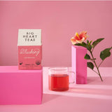 Blushing hibiscus tea steeped bright pink in a clear glass