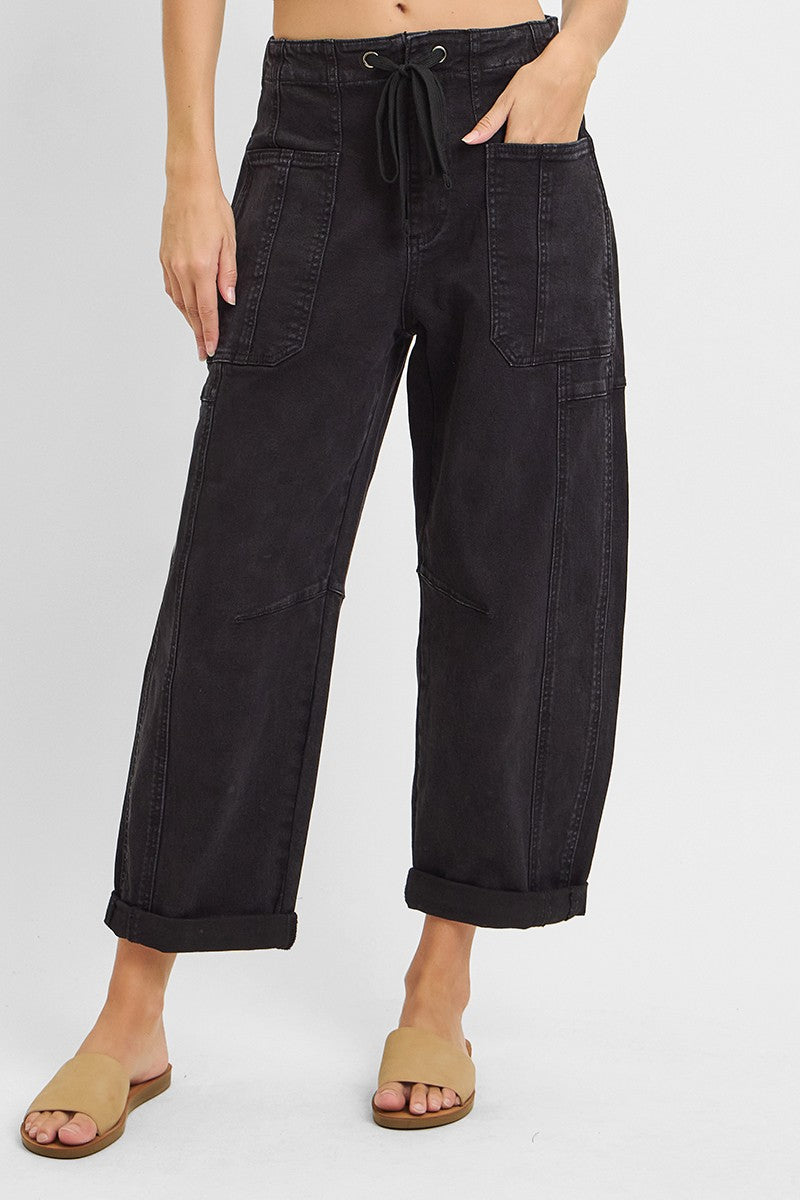 Black barrel leg cargo jeans styled with a simple top, full length view