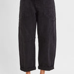 Black barrel leg cargo jeans showing curved thigh and tapered cropped hem