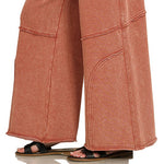 Lower leg detail of wide-leg flare pant with curved seam and raw hem