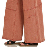Lower leg detail of wide-leg flare pant with curved seam and raw hem