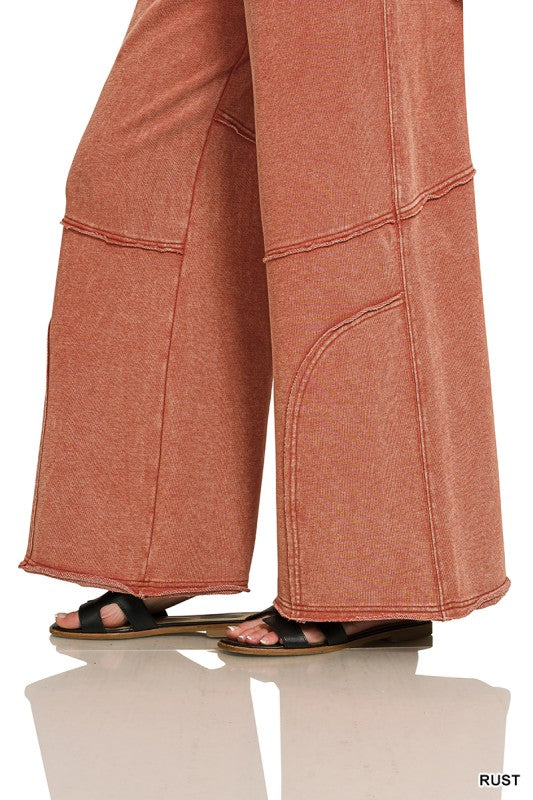 Lower leg detail of wide-leg flare pant with curved seam and raw hem