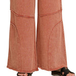Detail of exposed knee seam and raw hem on washed French terry flare pant