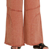 Detail of exposed knee seam and raw hem on washed French terry flare pant