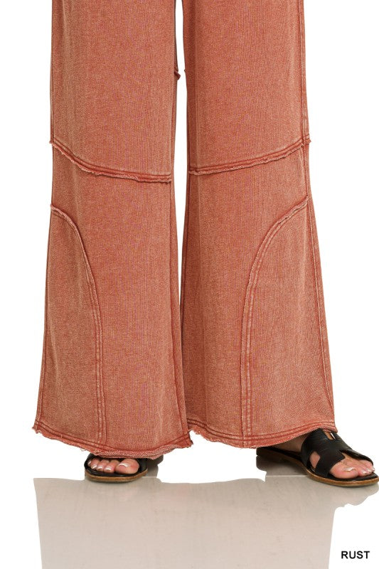 Detail of exposed knee seam and raw hem on washed French terry flare pant