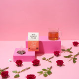 Cup of Love rose and tulsi tea brewed in a light ceramic cup