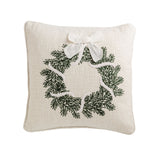 Square cream pillow with a green crewel-embroidered evergreen wreath and white bow