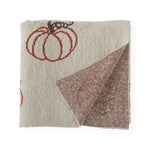 Folded cream knit pumpkin throw with corner turned back to show the rust and cream reverse