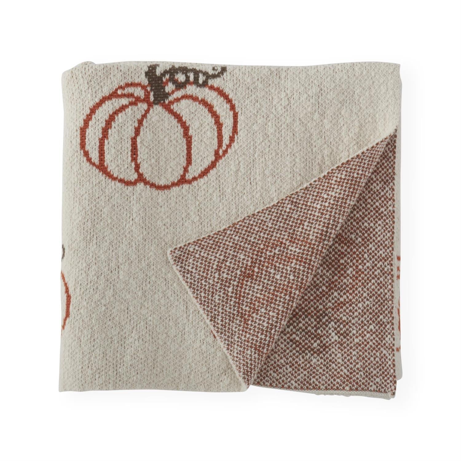 Folded cream knit pumpkin throw with corner turned back to show the rust and cream reverse
