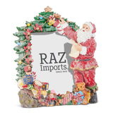 Resin picture frame wrapped in greenery, ornaments, and gifts, with Santa standing at one side