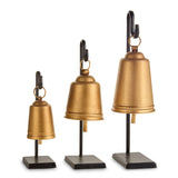 Three antique gold bells in graduated sizes hanging from slim black iron stands