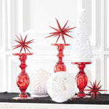 White acrylic LED globes lit on a mantel beside red glass candlesticks and red glittered stars