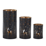 Three black metal cylinder lanterns with deer, tree and snowflake cutouts and copper-toned interiors