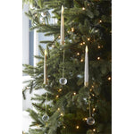 Gold LED taper candles clipped onto the branches of a lit Christmas tree with crystal weights