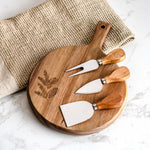 Round wood cheese board with engraved evergreen and three cheese knives
