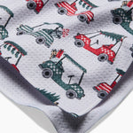Close-up of red and green golf cart Christmas tree print on tea towel