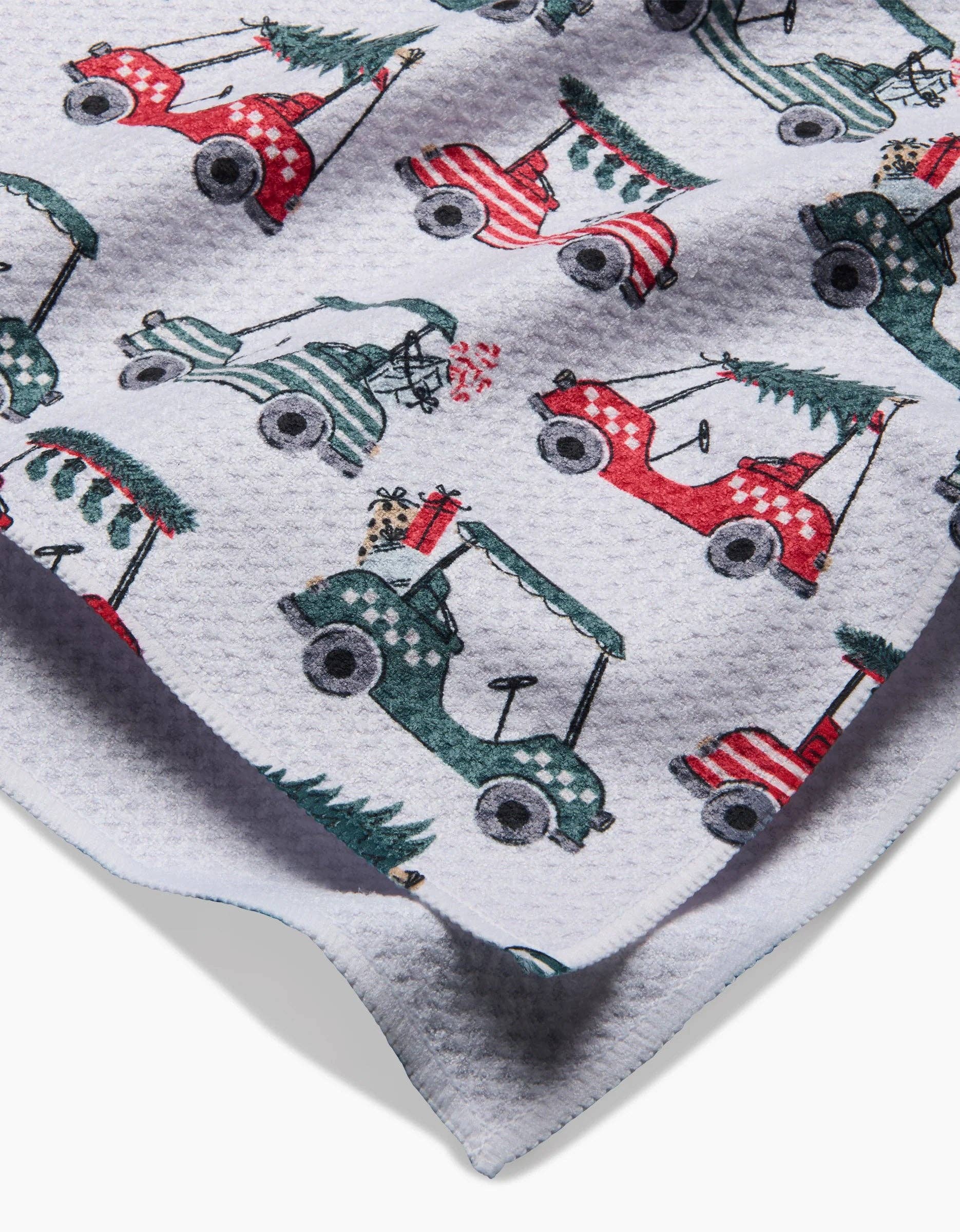 Close-up of red and green golf cart Christmas tree print on tea towel