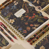 Spiral-bound art journal with a Forest Flowers illustrated cover, interior pages