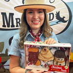 Woman in a straw cowboy hat holding the boxed Christmas Shapes seed ornament set