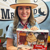 Woman in a straw cowboy hat holding the boxed Christmas Shapes seed ornament set