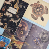 A5 ruled notebook with a galaxy and starfield cover design, interior ruled pages