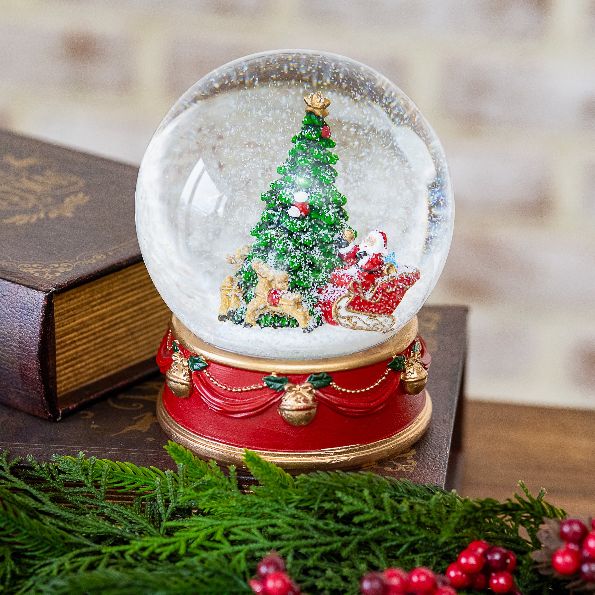 Large Christmas tree snow globe with presents on a red drum base