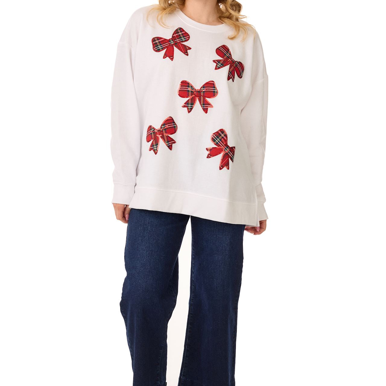 Model in a white sweatshirt with scattered red sparkle bows, jeans, and black boots