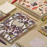Spiral-bound art journal with a painted iris cover, interior pages