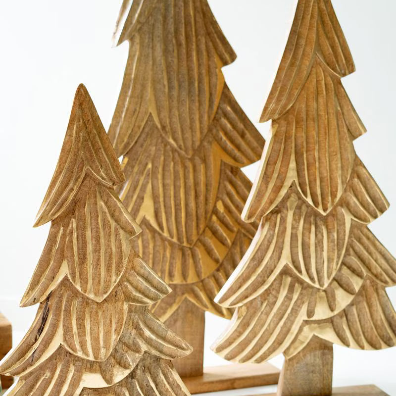 Trio of carved wood trees in small, medium and large sizes standing on wood bases against white