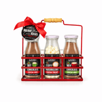 Red wire rack with a wooden handle holding hot chocolate, marshmallow, and milk chocolate bottles under a red bow