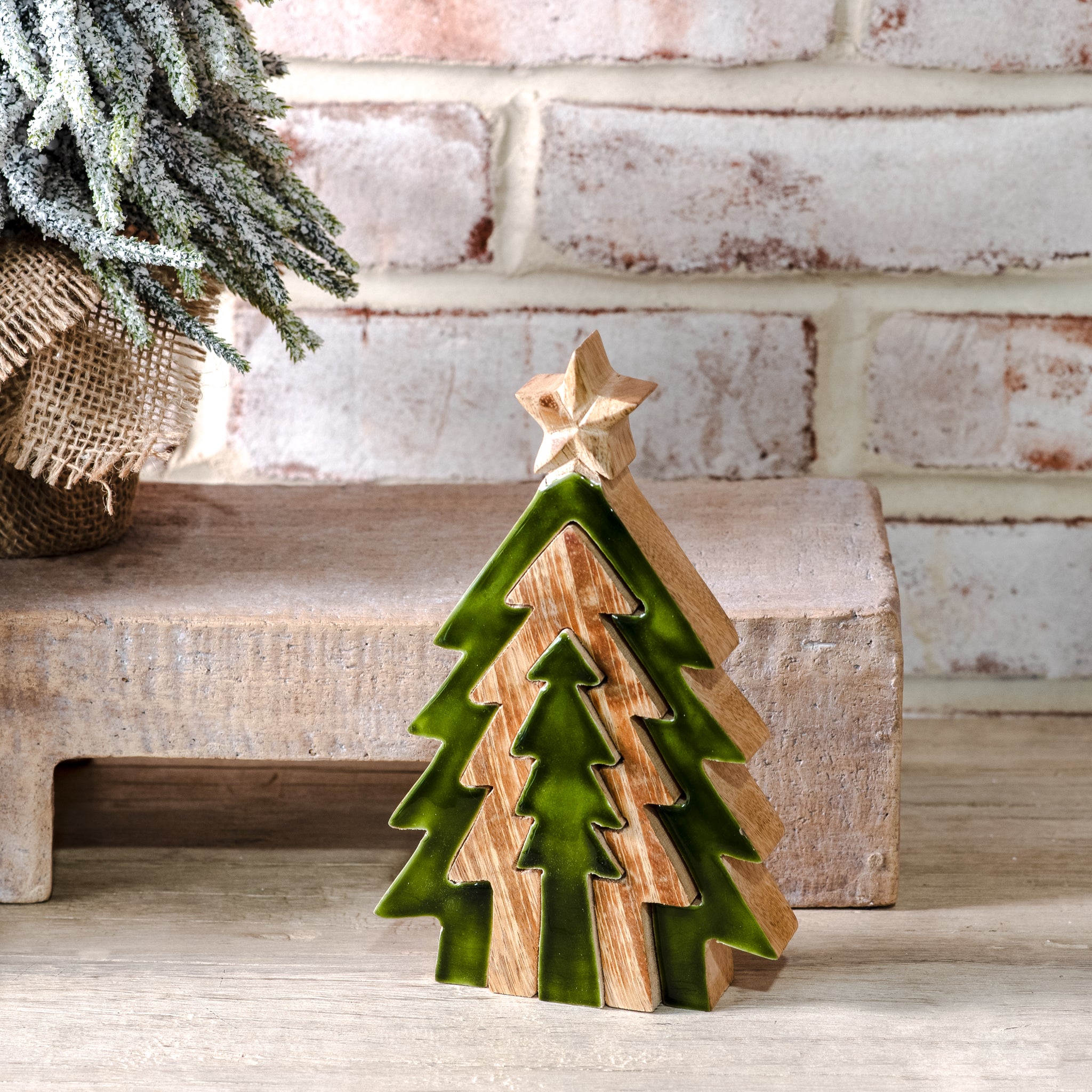 Small layered green and natural wood Christmas tree with gold star