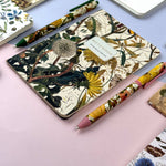A5 ruled notebook with a green botanical cover design, detail view