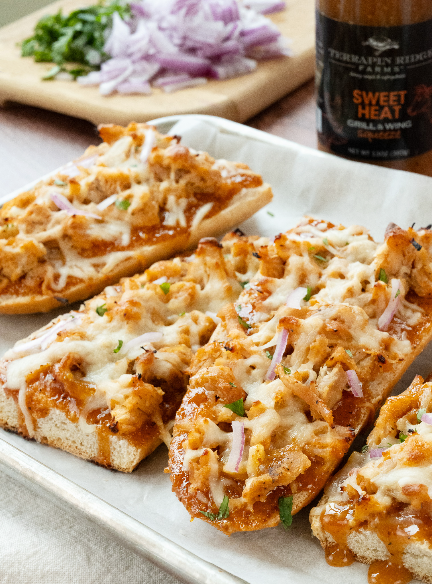 Toasted bread topped with shredded BBQ chicken, cheese and red onion