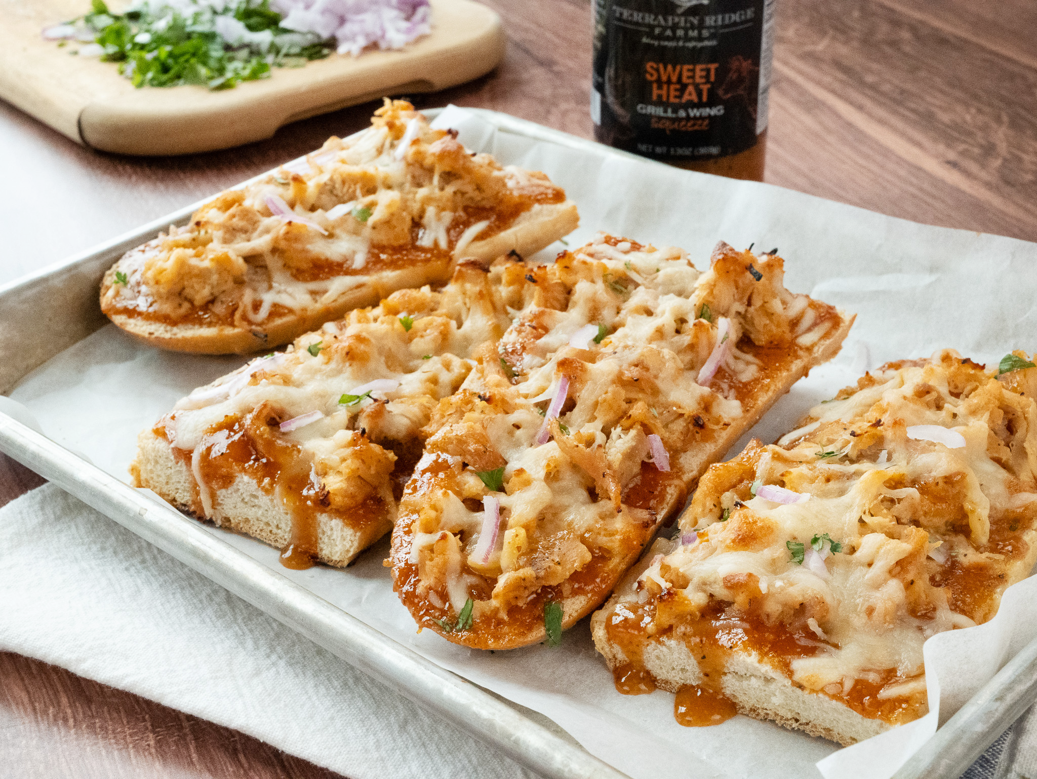 BBQ chicken flatbreads with melted cheese, red onion and cilantro made with Sweet Heat Grill & Wing Sauce