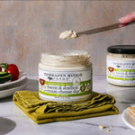 Open jar of Bacon Scallion Cream Cheese Dip with a knife and snacks