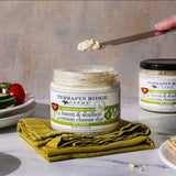 Open jar of Bacon Scallion Cream Cheese Dip with a knife and snacks