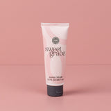 Sweet Grace Hand Cream tube with flip-top cap standing on a pink surface