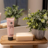 Sweet Grace Hand Cream styled on a wooden tray on a bathroom counter with soap and a small plant