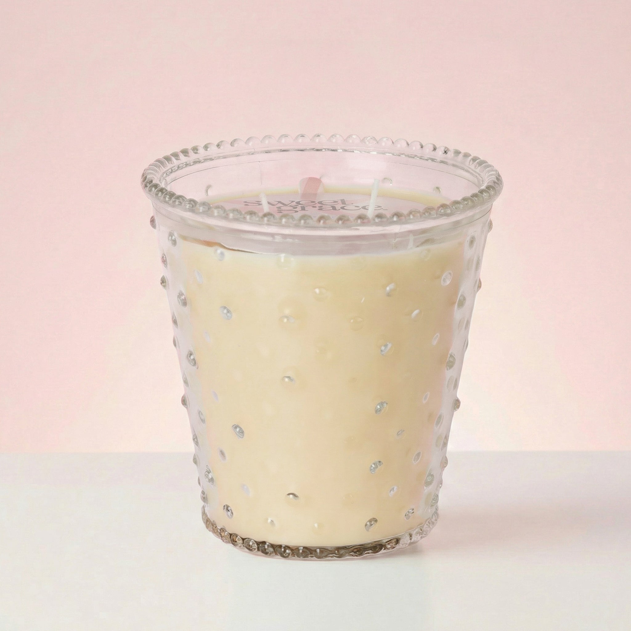 Bridgewater Sweet Grace hobnail glass candle lit, showing three wicks in cream soy-blend wax