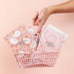 Hand tucking a Bridgewater Sweet Grace mod stripe sachet into a pink wire basket