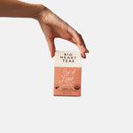 Hand holding a Cup of Love organic rose tea box