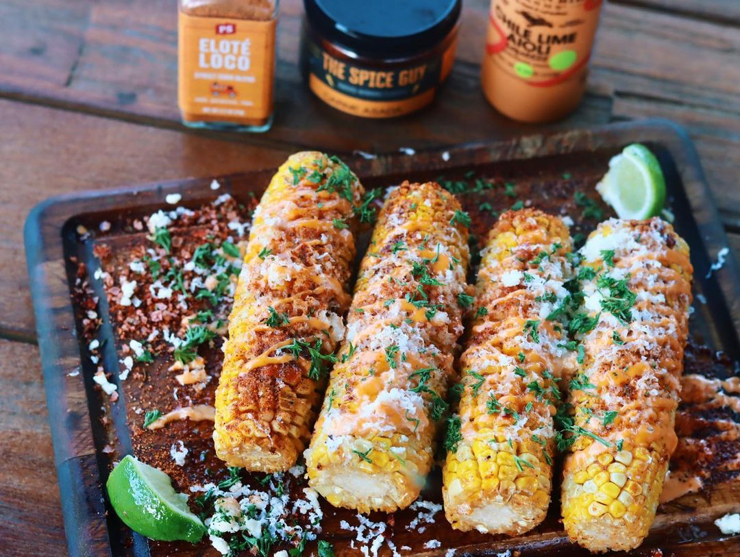 Grilled street corn topped with cheese, chili powder and Chile Lime Aioli